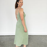 Back/side view of model wearing Aisling long organic cotton dress in rib, highlighting low-back design and natural drape. Naturally dyed mulberry green for sensitive skin