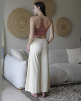 Back view of Danu organic cotton flare pants showing wide-leg cut and natural drape. Showing waistband folded down. Non toxic cream
