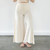 Front view of model wearing Danu organic cotton wide-leg flare pants, highlighting flattering seams and adjustable waistband. So natural in Cream