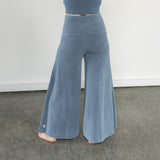 Back view of Danu organic cotton flare pants showing wide-leg cut and natural drape. Naturally dyed with Indigo