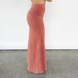 Side profile of Danu organic cotton flare pants, showcasing the customisable fold-over waistband and elegant flow. Naturally dyed with Rubia