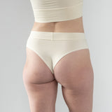 Back view of Meara on model, showcasing cheeky Brazilian-style coverage and comfortable cotton fabric. In cream