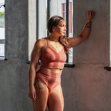 Model wearing High Meara organic cotton Brazilian brief, front view showing high-rise waist and leg-flattering cut. Rubia