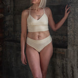 Model wearing the Meara Brazilian Brief in front profile. Soft, mid-rise fit in organic cotton in cream. Paired with Cream Branna bra
