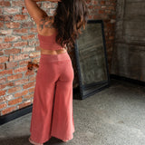 Back view of Danu organic cotton flare pants showing wide-leg cut and natural drape. Waintband folded down. Naturally dyed with Rubia for sensitive skin