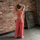 Back view of Danu organic cotton flare pants showing wide-leg cut and natural drape. Waintband folded down. Naturally dyed with Rubia for sensitive skin