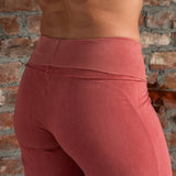 Close side profile of Danu organic cotton flare pants, showcasing the customisable fold-over waistband, elegant flow and curved seams. Naturally dyed in Rubia for sensitive skin