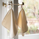 Cream organic cotton flannel hanging from a handy fabric loop, showcasing its soft double-sided texture and minimalist design