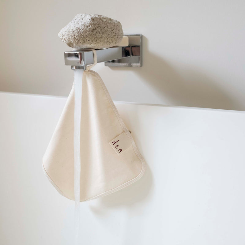 Cream organic cotton flannel hanging from a handy fabric loop, showcasing its soft double-sided texture and minimalist design